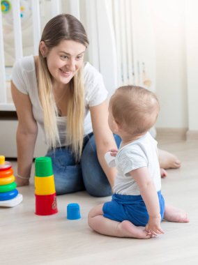 Gülümseyen anne onun erkek bebek oyuncak piramit montaj