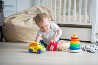 Katta oyuncakları ile oynarken şirin yürümeye başlayan çocuk