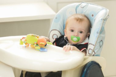 Çok güzel 9 aylık bebek çocuk oturan emzik ile portresi 