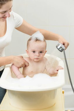 Banyo duş başlığı ile oynayan sevimli bebeğim