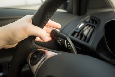 Kadın araba sürüş ve dönüş sinyali anahtarını kullanma