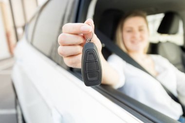 Gülümsemek gülümseyen kadın arabanın anahtarları tutan bir araba