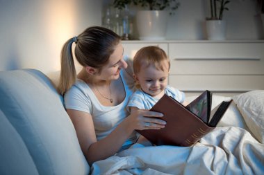 Güzel gülümseyen annesi okuma hikaye onun bebek çocuk önce gitmek için