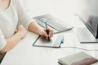 Genç kadın ofiste grafik tablet kullanarak closeup