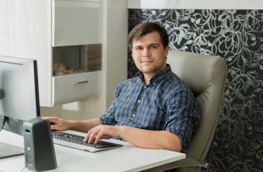 Evde çalışma office gülümseyen genç adam