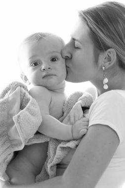 Siyah beyaz görüntü güzel genç annenin bebeğini öpüşme
