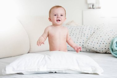 Gülümseyen bebek çocuk yatak büyük yastık ile oynamak