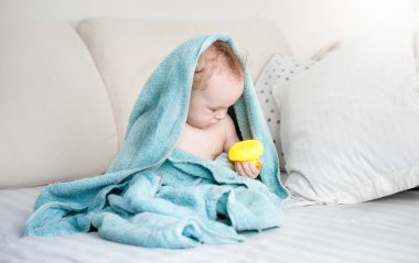 Mavi havlu sarı lastik ördek o ile oynarken kaplı erkek bebek