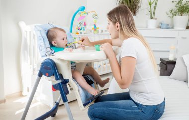 Yüksek sandalyede oturan ve yulaf lapası yemek bebek çocuk portresi