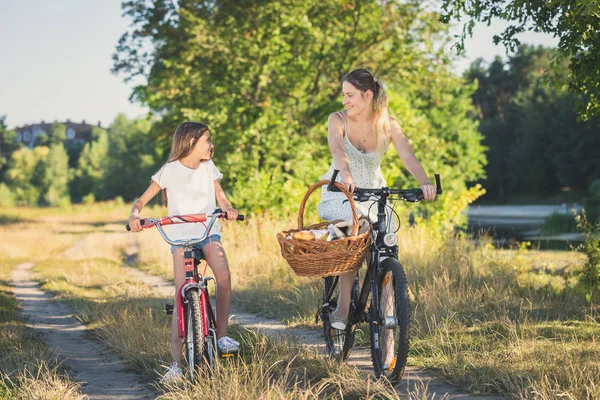 Joven madre ciclismo con hija montar a picnic — Foto de Stock