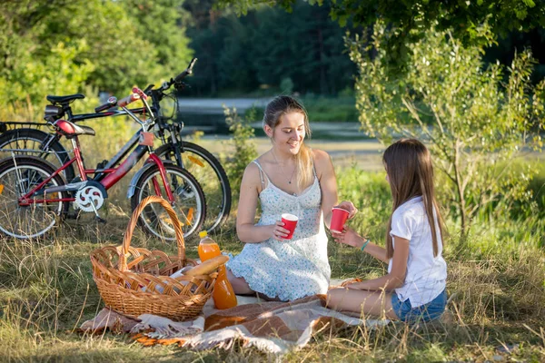 Una mujer de picnic junto al río con una hija de 10 años. Dos. — Foto de Stock