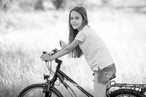 La imagen monocromática de la muchacha hermosa adolescente que monta la bicicleta en mea — Foto de Stock