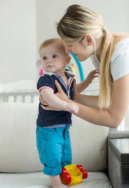 Mulher ensinando andando seu filho bebê de 1 ano de idade na cama — Fotografia de Stock