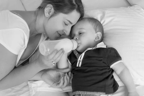 Portrait noir et blanc de belle jeune femme nourrissant son bab — Photo