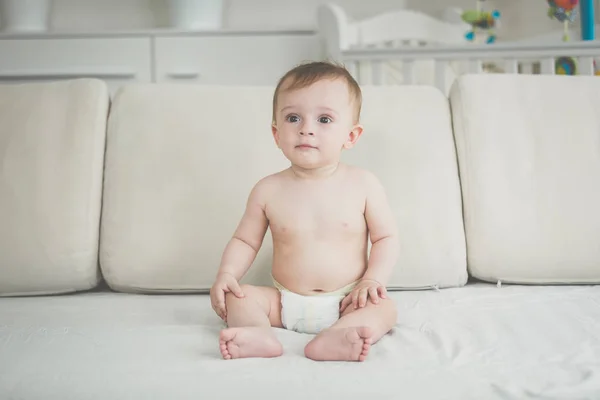 坐在客厅沙发上的纸尿裤男婴 — 图库照片