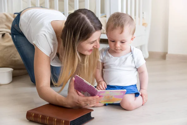 Kniha matka čtení k její 10 měsíců starý chlapeček na podlaze v li — Stock fotografie