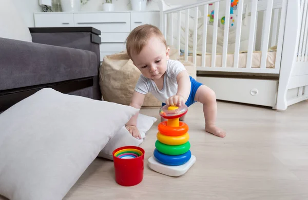 Baby pojke kryper på golvet i vardagsrummet och nå för leksak t — Stockfoto