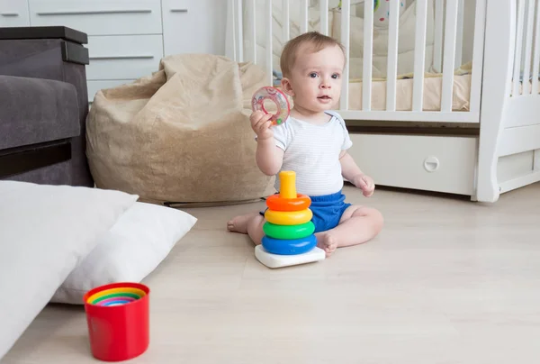 9 months old baby boy playing on floor with toy tower — Stock Photo, Image