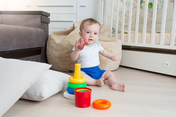 9 månader gammal pojke leker med leksak tornet på vardagsrum — Stockfoto