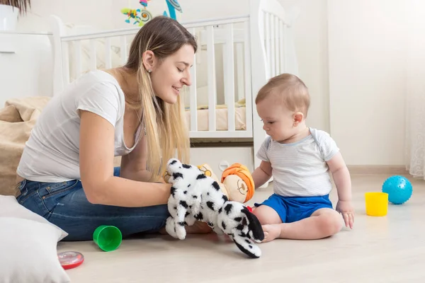 Sonriente madre con títere de perro en la mano y jugando con su b — Foto de Stock