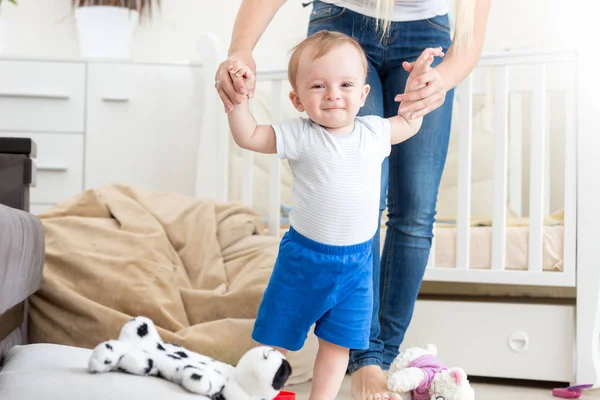 Adorável bebê aprendendo a andar com a mãe em casa — Fotografia de Stock