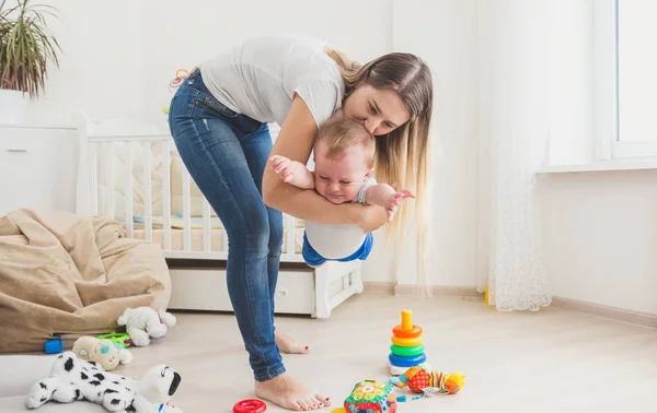 Cheerful mother playing with her baby boy at living room — Stock Photo, Image