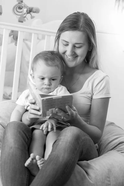 Preto e branco retrato de jovem mãe sentado com o bebê em ser — Fotografia de Stock