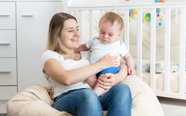 Kniha čtení veselá mladá matka její chlapeček v živé roo — Stock fotografie