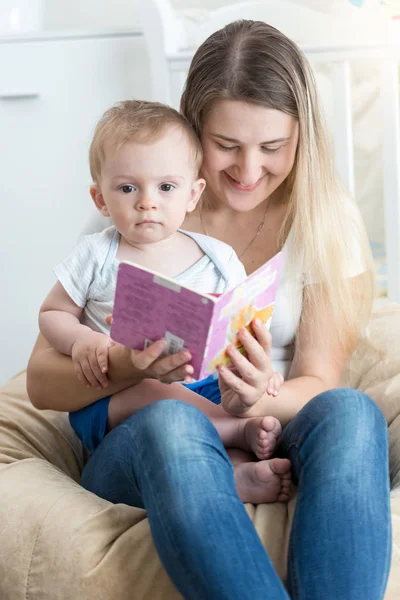 Bella sorridente madre che legge la storia al suo bambino di 9 mesi — Foto Stock