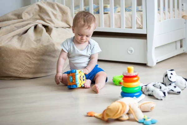 9 hónapos kisfiú játszik a játékautó és játékot torony — Stock Fotó
