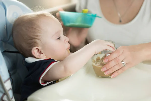 Wanita makan bayinya dari sendok dengan saus apel — Stok Foto