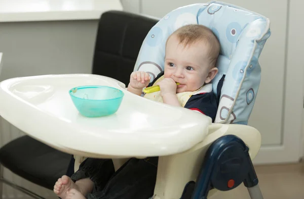 Little baby boy playing with food and dish while eating — Stock Photo, Image