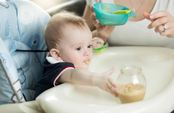 Closeup of mother feeding baby boy with porridge — Stock Photo, Image