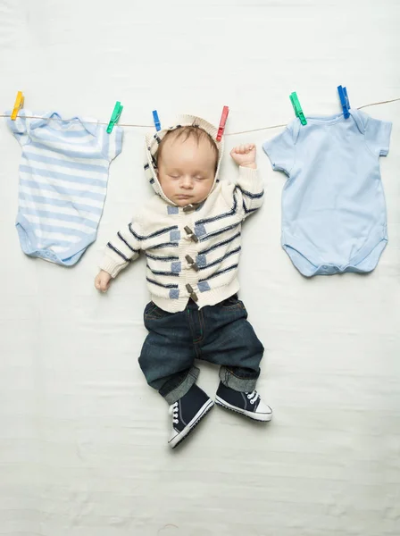 Funny photo of cute baby boy hanging on clothesline — Stock Photo, Image