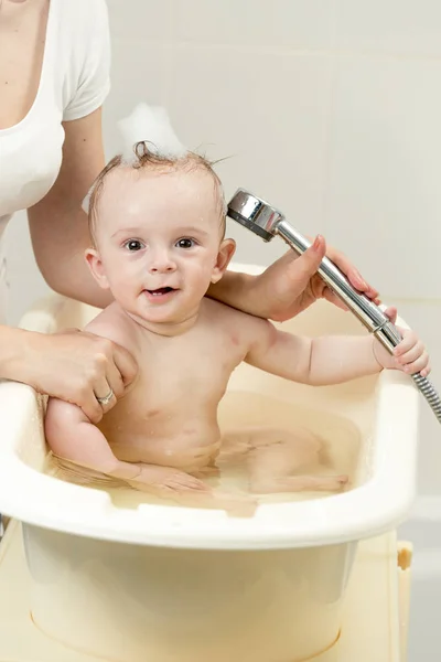 Alegre bebé niño teniendo baño y jugando con la cabeza de la ducha — Foto de Stock