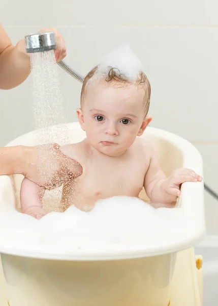 Lindo niño sentado en el baño lleno de espuma — Foto de Stock