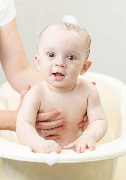 Lindo bebé jugando con juguetes mientras toma un baño — Foto de Stock