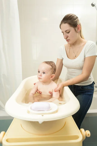Madre sosteniendo a su bebé en toalla en el baño — Foto de Stock