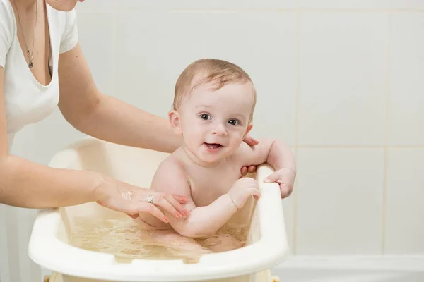 Madre bañando a su adorable bebé en el baño — Foto de Stock