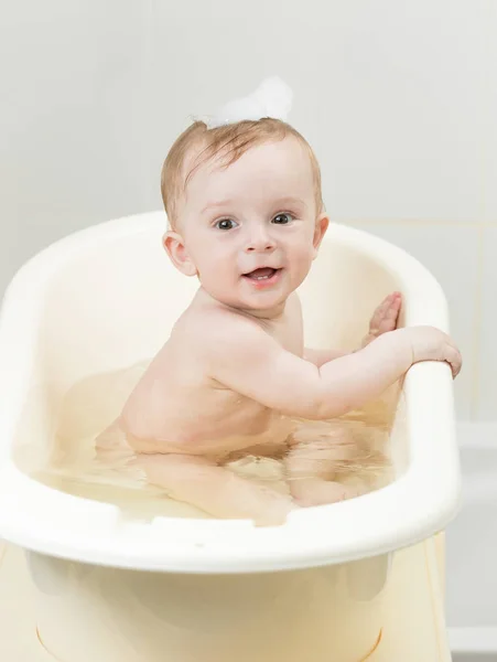 Bebé niño jugando en espuma mientras toma el baño — Foto de Stock