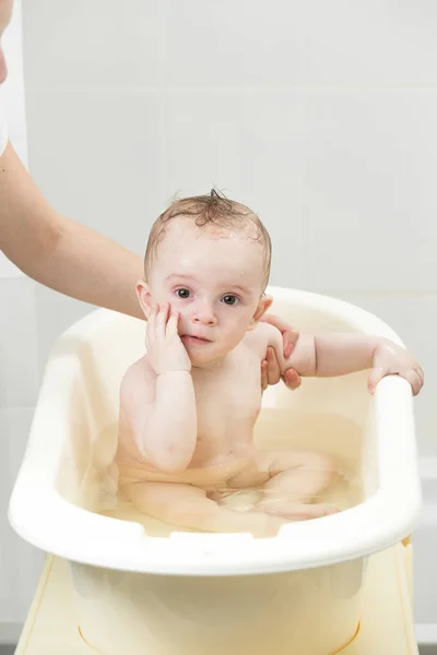 Lindo bebé sonriente sentado en el baño y mirando a la cámara — Foto de Stock