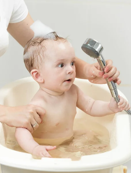 Feliz bebé alegre jugando con la cabeza de la ducha — Foto de Stock