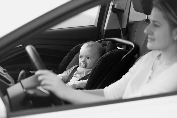 Retrato en blanco y negro de la madre conduciendo el coche con su niñera — Foto de Stock