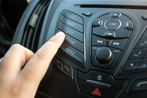 Крупный план женского пальца, нажимающего радиокнопку на автомобильном контроле pa — стоковое фото