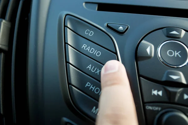 Foto di primo piano del conducente che preme il pulsante radio sul cruscotto — Foto Stock