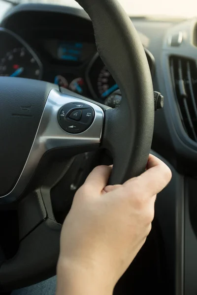 Closeup photo of woman holding leather steering wheel — Stock Photo, Image