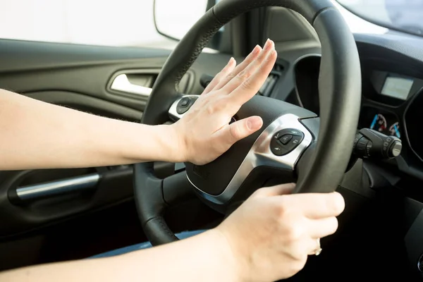 Imagen de primer plano de mujer molesta conduciendo coche y tocando la bocina — Foto de Stock