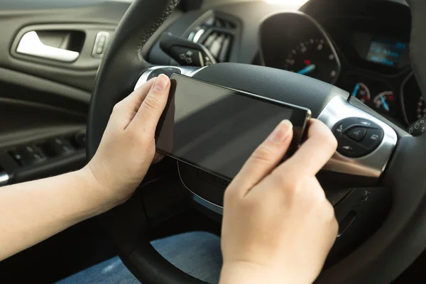 Γυναίκα οδήγηση ενός αυτοκινήτου και πληκτρολογώντας το μήνυμα στο τηλέφωνο — Φωτογραφία Αρχείου