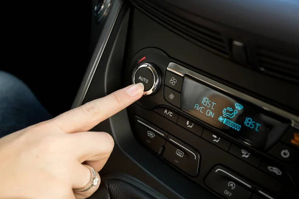 Primer plano de la mujer que ajusta la temperatura en el control climático del coche sy — Foto de Stock