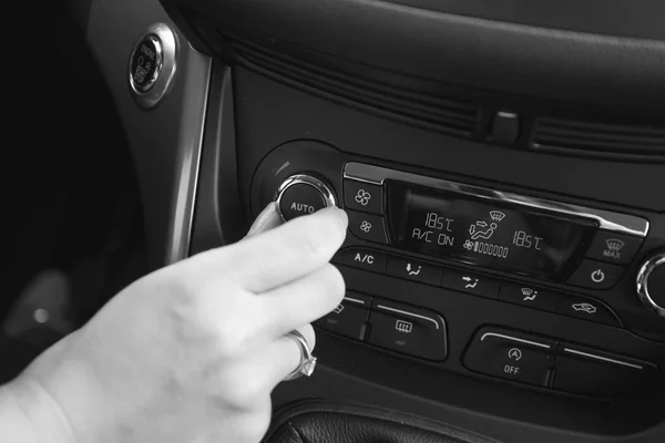 Imagen en blanco y negro de la mano que ajusta la temperatura del aire acondicionado del coche — Foto de Stock